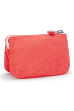 Kipling Creativity Small Purse. A small coral purse with zipper compartment, multiple inner compartments, Kipling logo, and monkey charm.