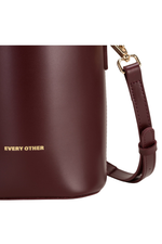 An image of the Every Other Solara Bucket Bag in Burgundy.