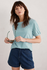 An image of a female model wearing the Seasalt Oleander Blouson Sleeve T-Shirt in the colour Profile Chalk Tidepool.