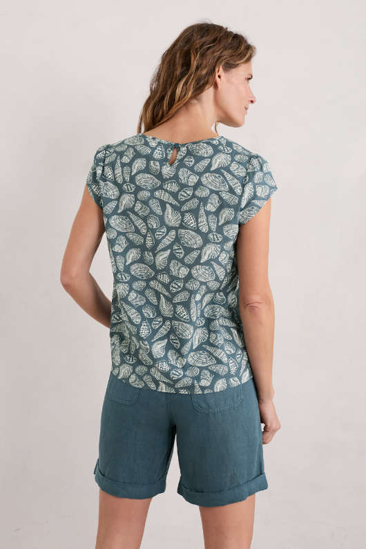 An image of a female model wearing the Seasalt Garden Gate Cotton Top in the colour Pocket Shells Pool.