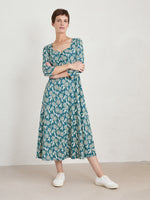 Seasalt Secret Cove Dress. A midi length dress with 3/4 length sleeves, sweetheart neckline, and skimming skirt. This dress is green with a dandelion print.