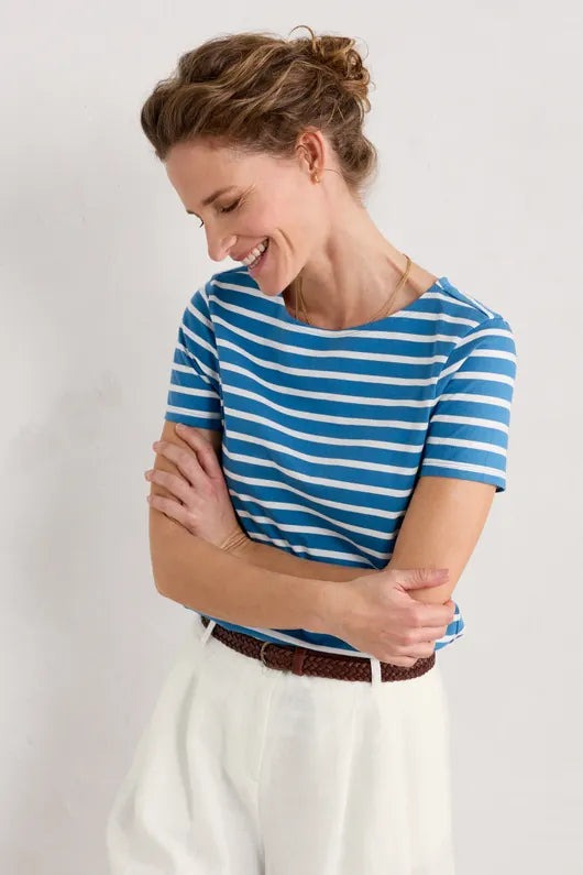 An image of a female model wearing the Seasalt Sailor T-Shirt in the colour Breton Sailboats Chalk.