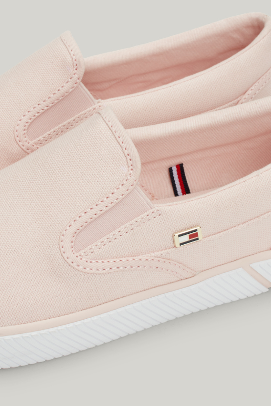 An image of the Tommy Hilfiger Enamel Flag Slip-On Canvas Trainers in the colour Whimsy Pink.