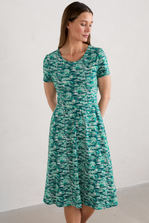 An image of a female model wearing the Seasalt April Short Sleeve Dress in the colour Helford Boats Dark Wreckage.