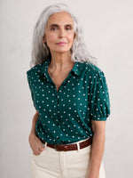 Seasalt Embrace Shirt. A green shirt with white polka dots, featuring a slightly fitted cut, collar, gathered short sleeves and button fastenings.