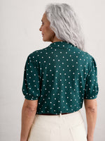 Seasalt Embrace Shirt. A green shirt with white polka dots, featuring a slightly fitted cut, collar, gathered short sleeves and button fastenings.