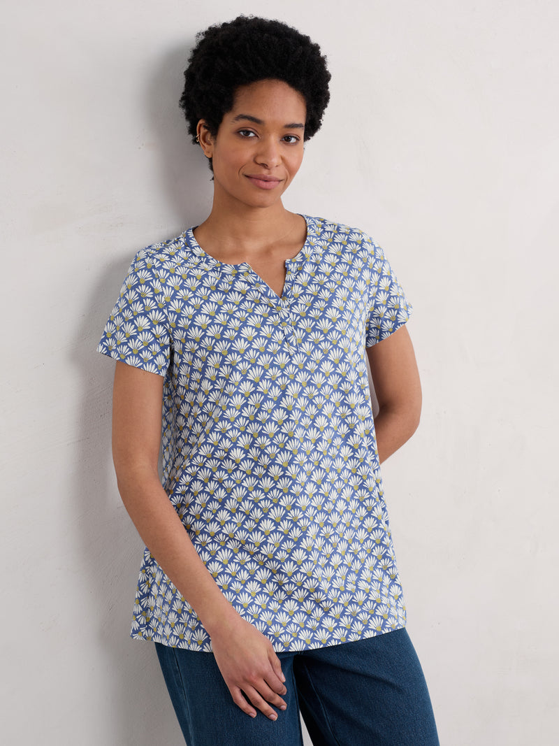An image of a model wearing the Seasalt Short-Sleeved Risso Top in the style Little Echinacea Lupin.
